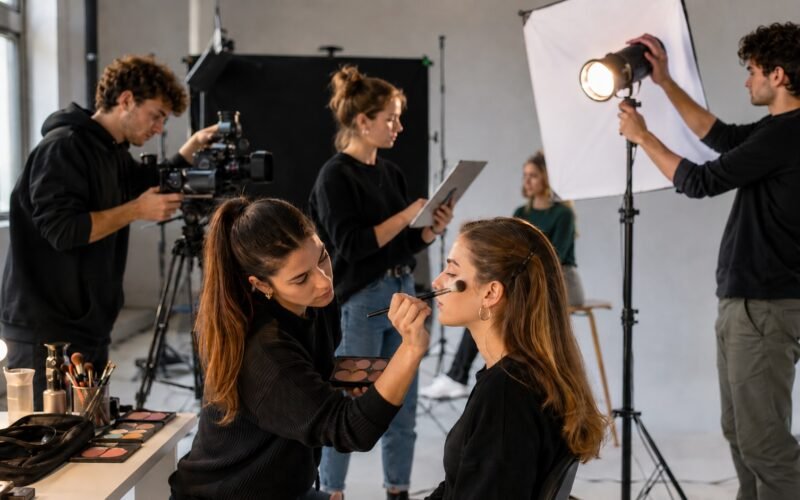 Estudiante de Thuya aplicando maquillaje profesional en un rodaje universitario de la UAO CEU